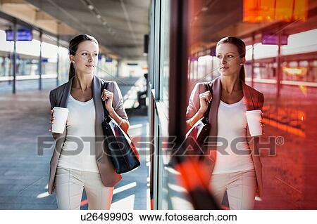 Portrait of young attractive businesswoman holding cup of coffee while walking View Large Photo Image Stock Image - Portrait of young attractive businesswoman holding cup of coffee while walking. Fotosearch