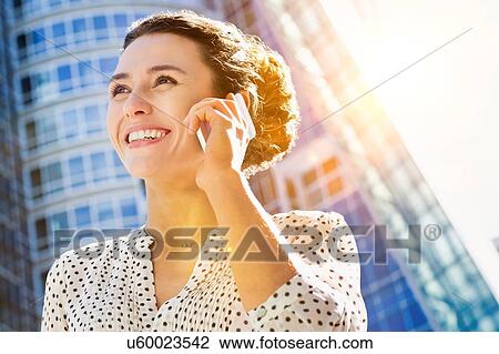 Portrait of young attractive businesswoman smiling while talking on smartphone View Large Photo Image Stock Image - Portrait of young attractive businesswoman smiling while talking on smartphone . Fotosearch