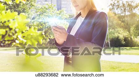 Portrait of young attractive businesswoman using smartphone in park View Large Photo Image Stock Image - Portrait of young attractive businesswoman using smartphone in park. Fotosearch