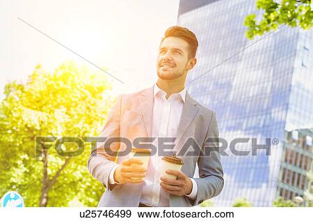 Portrait of young attractive businessman holding two cups of coffee View Large Photo Image Stock Photo - Portrait of young attractive businessman holding two cups of coffee . Fotosearch