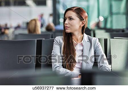 Portrait of young attractive businesswoman sitting while waiting in her gate for boarding at airport View Large Photo Image Stock Photo - Portrait of young attractive businesswoman sitting while waiting in her gate for boarding at airport. Fotosearch
