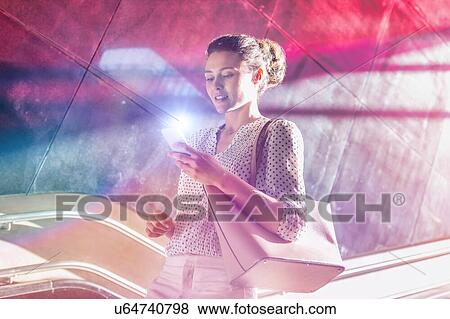 Portrait of young attractive businesswoman using smartphone while walking downstairs View Large Photo Image Stock Photo - Portrait of young attractive businesswoman using smartphone while walking downstairs. Fotosearch