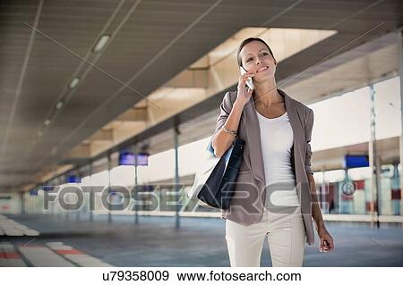 Stock Photo - Portrait of young attractive businesswoman talking smartphone. Fotosearch