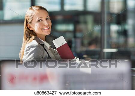 Portrait of young attractive businesswoman holding her passport and boarding pass in airport View Large Photo Image Stock Photo - Portrait of young attractive businesswoman holding her passport and boarding pass in airport. Fotosearch