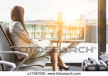 Portrait of young attractive businesswoman sitting while waiting in her gate for boarding at airport View Large Photo Image Stock Photography - Portrait of young attractive businesswoman sitting while waiting in her gate for boarding at airport. Fotosearch