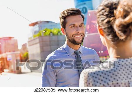 Portrait of young attractive businessman smiling while talking to businesswoman View Large Photo Image Stock Photography - Portrait of young attractive businessman smiling while talking to businesswoman. Fotosearch