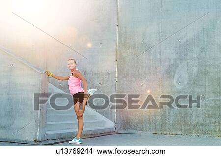 Picture - Portrait of young attractive woman stretching her legs. Fotosearch