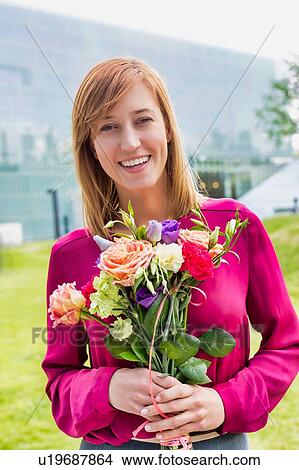 Portrait of young attractive woman holding boquet of flowers View Large Photo Image Picture - Portrait of young attractive woman holding boquet of flowers. Fotosearch