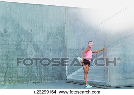 Picture - Portrait of young attractive woman stretching her legs. Fotosearch