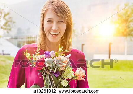 Portrait of young attractive woman holding boquet of flowers View Large Photo Image Stock Image - Portrait of young attractive woman holding boquet of flowers. Fotosearch