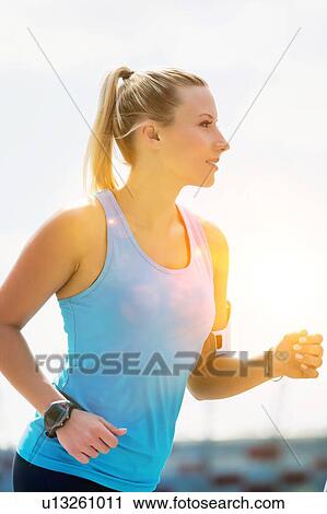 Portrait of young attractive woman running in park View Large Photo Image Stock Image - Portrait of young attractive woman running in park. Fotosearch