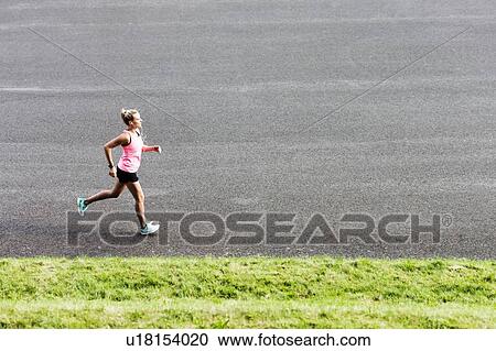 Portrait of young attractive woman running in park View Large Photo Image Stock Image - Portrait of young attractive woman running in park. Fotosearch