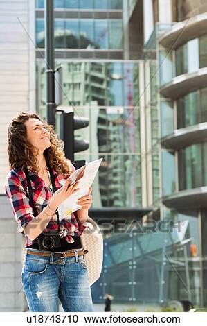 Portrait of young attractive woman looking on the map in the city with lens flare in background View Large Photo Image Stock Image - Portrait of young attractive woman looking on the map in the city with lens flare in background. Fotosearch