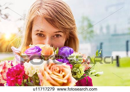 Stock Photo - Portrait of young attractive woman holding boquet of flowers. Fotosearch