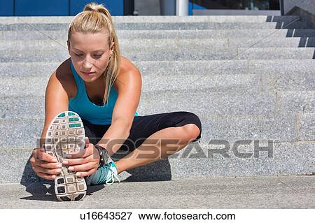 Portrait of young attractive woman stretching her legs View Large Photo Image Stock Photo - Portrait of young attractive woman stretching her legs. Fotosearch