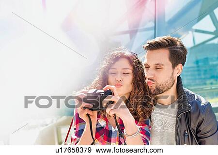 Portrait of young attractive woman taking selfie with her boyfriend in the middle of the city View Large Photo Image Stock Photo - Portrait of young attractive woman taking selfie with her boyfriend in the middle of the city. Fotosearch