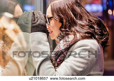 Portrait of young attractive woman looking at the dress on a manequin in shop through the window View Large Photo Image Stock Photo - Portrait of young attractive woman looking at the dress on a manequin in shop through the window. Fotosearch