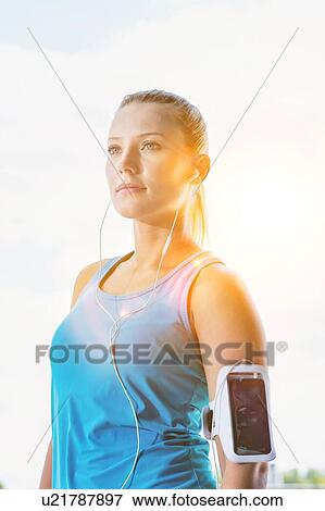 Stock Photo - Portrait of young attractive woman running in park. Fotosearch