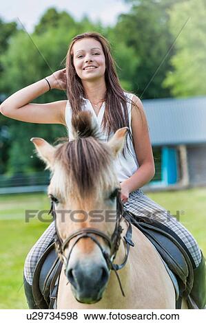 Portrait of young attractive woman riding horse in ranch View Large Photo Image Stock Photo - Portrait of young attractive woman riding horse in ranch. Fotosearch