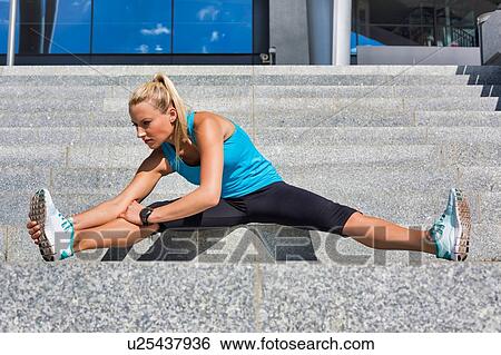Portrait of young attractive woman stretching her legs View Large Photo Image Stock Photograph - Portrait of young attractive woman stretching her legs. Fotosearch