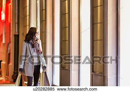 Portrait of young attractive woman looking at the dress on a manequin in shop through the window View Large Photo Image Stock Photography - Portrait of young attractive woman looking at the dress on a manequin in shop through the window. Fotosearch