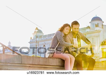 Portrait of young attractivec couple sitting while looking on the map View Large Photo Image Stock Image - Portrait of young attractivec couple sitting while looking on the map. Fotosearch