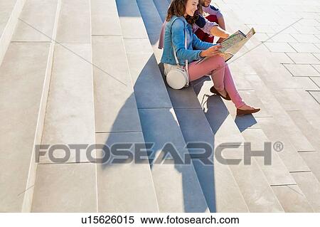 Stock Photography - Portrait of young attractivec couple sitting while looking on the map. Fotosearch