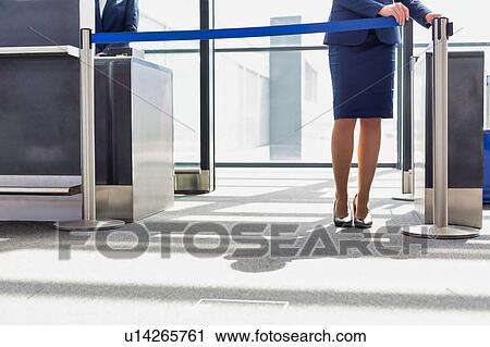 Stock Image - Portrait of young beautiful airport staff opening the gate for boarding in airport . Fotosearch