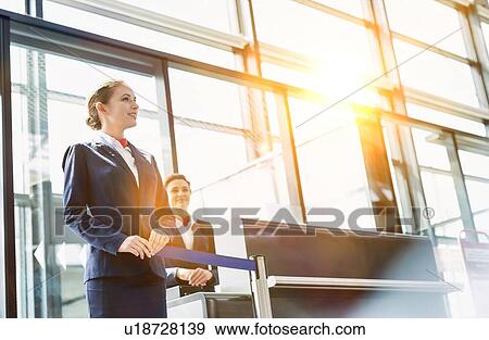 Portrait of young beautiful airport staff opening the gate for boarding in airport View Large Photo Image Stock Photo - Portrait of young beautiful airport staff opening the gate for boarding in airport . Fotosearch