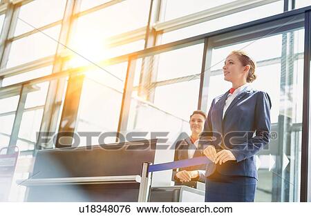 Portrait of young beautiful airport staff opening the gate for boarding in airport View Large Photo Image Stock Photograph - Portrait of young beautiful airport staff opening the gate for boarding in airport . Fotosearch