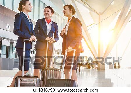 Portrait of young beautiful confident flight attendants talking in airport View Large Photo Image Stock Image - Portrait of young beautiful confident flight attendants talking in airport. Fotosearch
