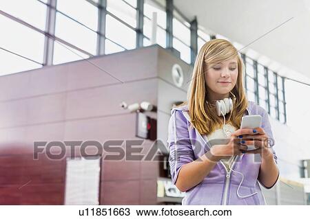 Portrait of young beautiful teenage girl using smartphone in airport with lens flare View Large Photo Image Stock Image - Portrait of young beautiful teenage girl using smartphone in airport with lens flare. Fotosearch