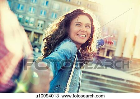 Portrait of young beautiful woman posing while being photograph by his boyfriend with lens flare in background View Large Photo Image Stock Image - Portrait of young beautiful woman posing while being photograph by his boyfriend with lens flare in background. Fotosearch