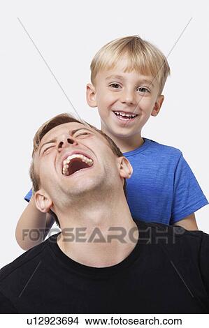 Picture - Portrait of young boy playing with father over white background. Fotosearch