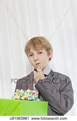 Portrait of young boy staring with hand on chin View Large Photo Image Stock Image - Portrait of young boy staring with hand on chin. Fotosearch