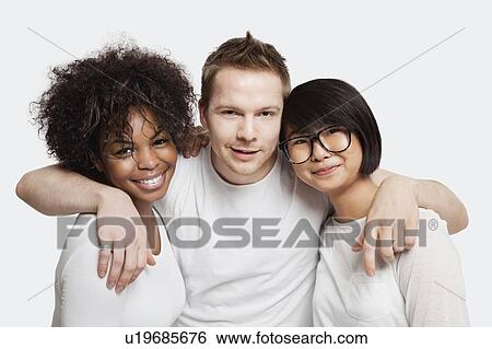 Portrait of young Caucasian man with his arms around two female friends over white background View Large Photo Image Stock Photograph - Portrait of young Caucasian man with his arms around two female friends over white background. Fotosearch