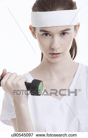 Portrait of young Caucasian woman with dumbbell against white background View Large Photo Image Stock Photo - Portrait of young Caucasian woman with dumbbell against white background. Fotosearch