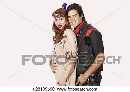 Stock Image - Portrait of young couple in old-fashioned costumes smiling against gray background. Fotosearch
