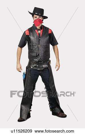 Portrait of young cowboy standing against gray background View Large Photo Image Stock Photo - Portrait of young cowboy standing against gray background. Fotosearch