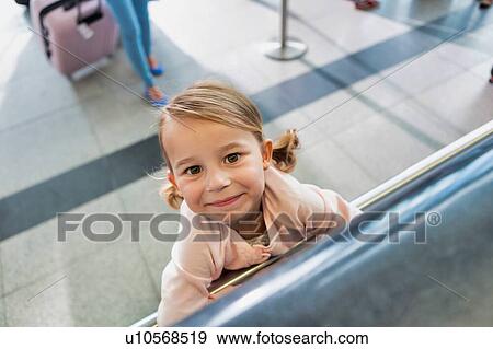 Stock Photo - Portrait of young cute little girl being playful in check in at airport. Fotosearch