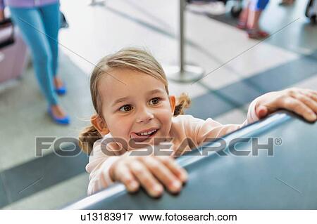 Stock Photo - Portrait of young cute little girl being playful in check in at airport. Fotosearch