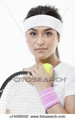 Stock Image - Portrait of young female tennis player against white background. Fotosearch