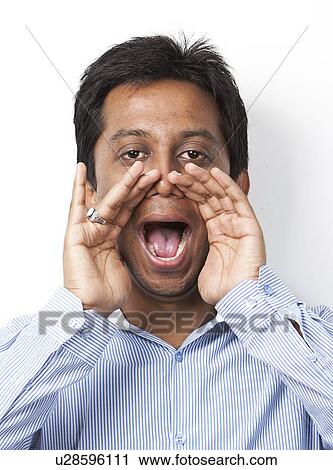 Portrait of young Indian man shouting against white background View Large Photo Image Stock Image - Portrait of young Indian man shouting against white background. Fotosearch