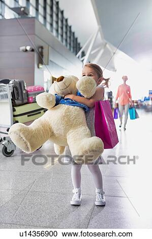 Portrait of young little girl holding her big teddy bear in airport View Large Photo Image Stock Image - Portrait of young little girl holding her big teddy bear in airport. Fotosearch