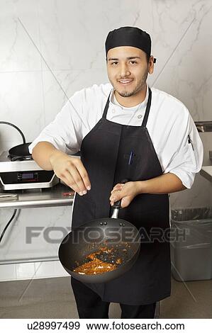 Portrait of young male chef cooking food View Large Photo Image Stock Photo - Portrait of young male chef cooking food. Fotosearch