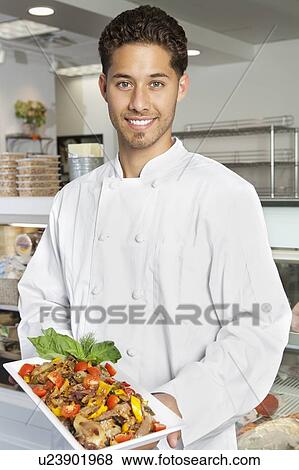 Portrait of young male chef holding chicken salad in serving dish View Large Photo Image Stock Photo - Portrait of young male chef holding chicken salad in serving dish. Fotosearch