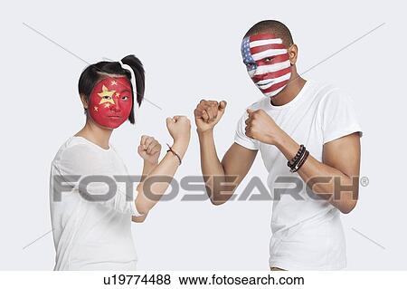 Portrait of young man and woman with national flags painted on face holding up their fists to fight against white background View Large Photo Image Stock Photo - Portrait of young man and woman with national flags painted on face holding up their fists to fight against white background. Fotosearch