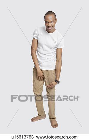 Portrait of young man in casuals smiling against white background View Large Photo Image Stock Image - Portrait of young man in casuals smiling against white background. Fotosearch