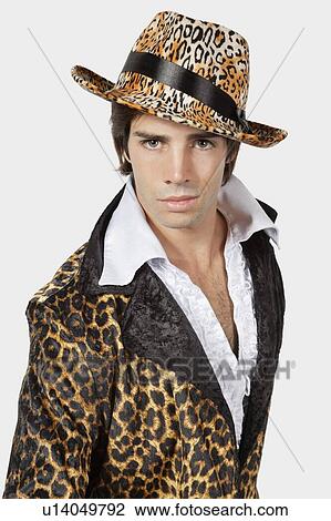 Stock Image - Portrait of young man in fur clothing against gray background. Fotosearch