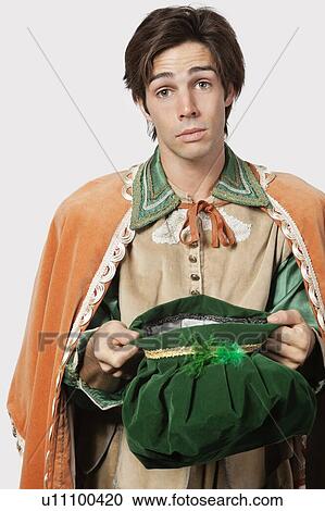 Portrait of young man in old-fashioned costume begging against gray background View Large Photo Image Stock Image - Portrait of young man in old-fashioned costume begging against gray background. Fotosearch